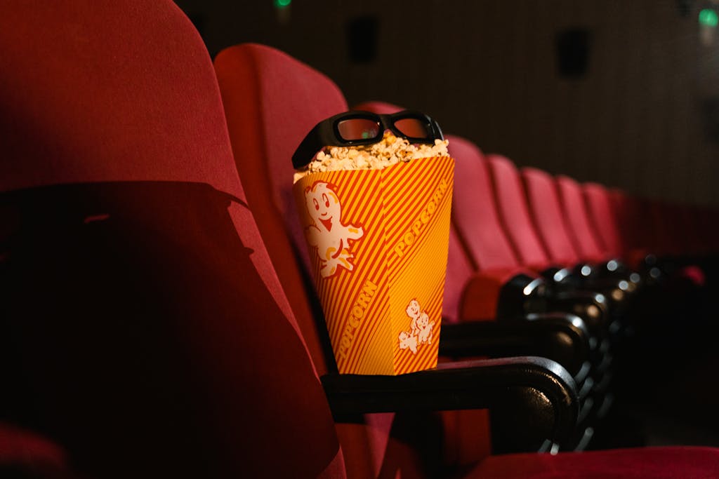 Cinema seat with popcorn and 3D glasses perfectly capturing the movie theater experience.